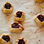 A close up of mini blueberry galettes on parchment paper.