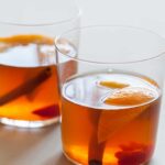 The perfect winter cocktail, a Winter Spiced Old Fashioned with cinnamon, star anise, cardamom, cherries, and orange slices.