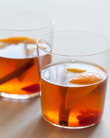 The perfect winter cocktail, a Winter Spiced Old Fashioned with cinnamon, star anise, cardamom, cherries, and orange slices.