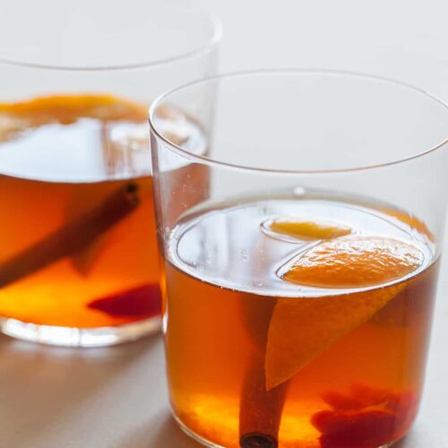 The perfect winter cocktail, a Winter Spiced Old Fashioned with cinnamon, star anise, cardamom, cherries, and orange slices.