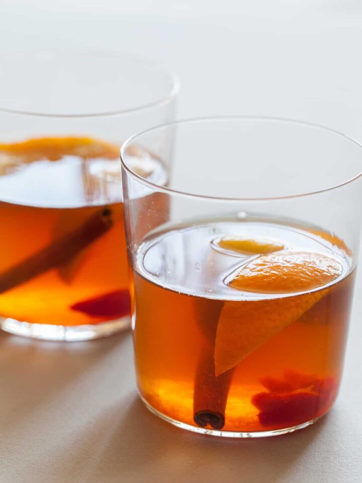 The perfect winter cocktail, a Winter Spiced Old Fashioned with cinnamon, star anise, cardamom, cherries, and orange slices.