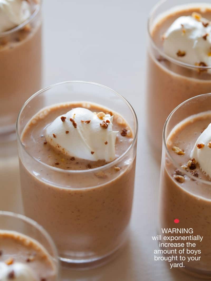 A close up of Snickers milkshakes with whipped cream and sprinkled chopped Snickers bars.
