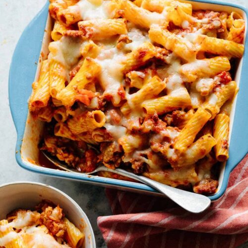 Baked Ziti in a blue pan with a spoon.