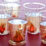 A close up of glasses of hibiscus ginger champagne cocktails.