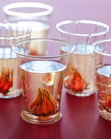 A close up of glasses of hibiscus ginger champagne cocktails.
