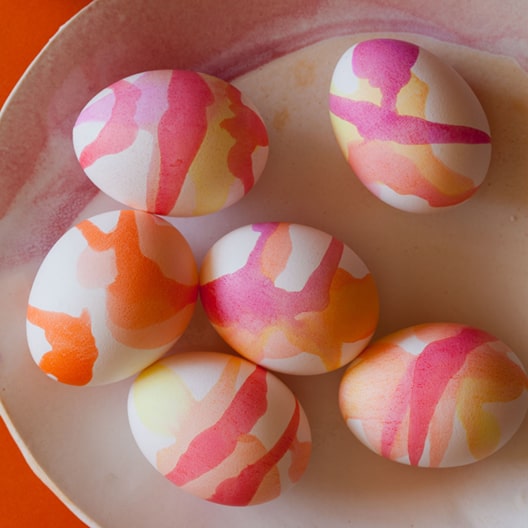 Watercolor dyed easter eggs on a plate. 