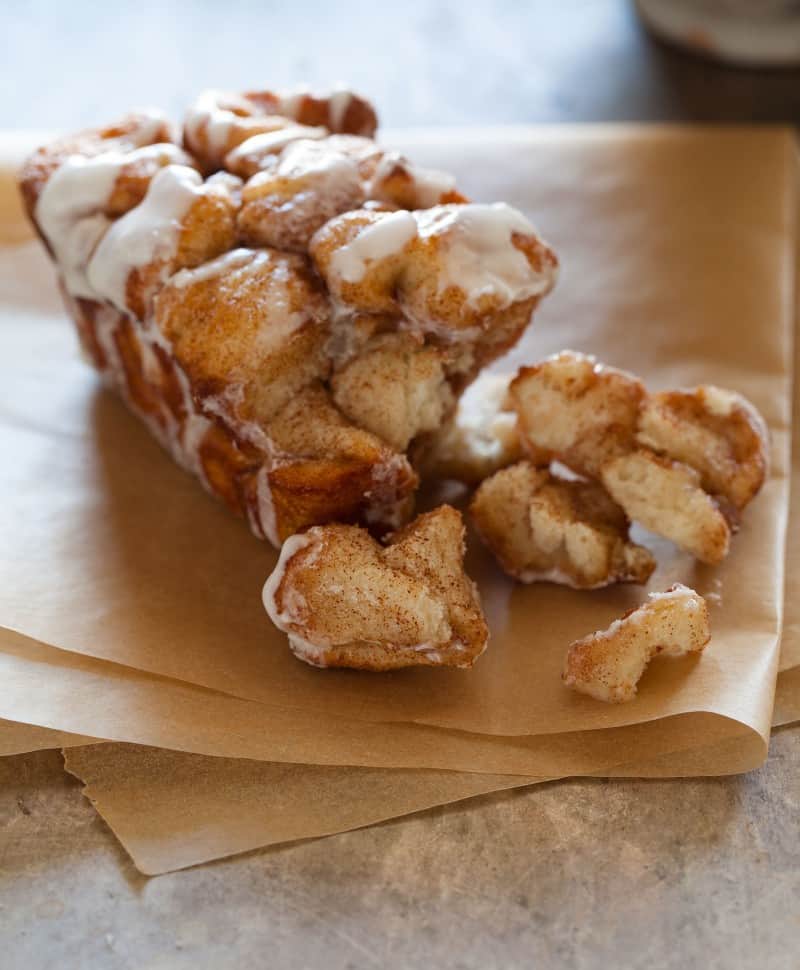 A close up of cinnamon sugar messy bread with some pieces pulled off the end.