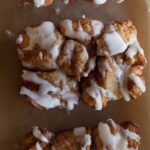 A close up of a piece of cinnamon sugar messy bread with vanilla icing.