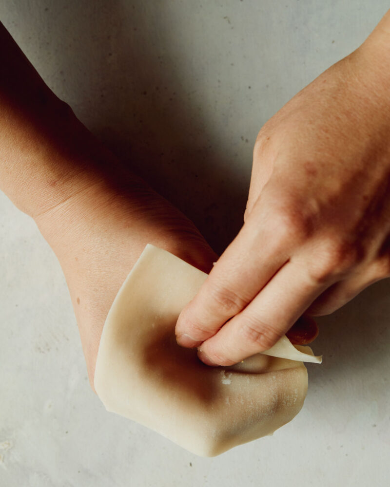 Step 2 of forming shrimp shumai. Gently press the wonton wrapper into your hand to create a cavity for the shrimp mixture to sit in. 