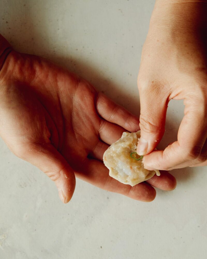 Step 6 of making Shrimp Shumai. Place a scallion slice on the top of each shrimp shumai.