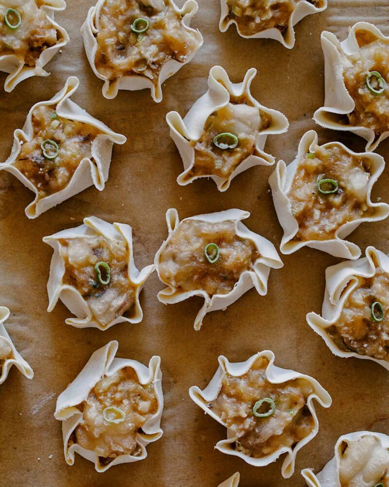 Overhead of 14 frozen shrimp shumai on parchment paper as per directions. 