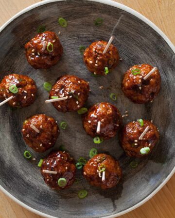 Cocktail meatballs with a Korean chili sauce, topped with green onions.