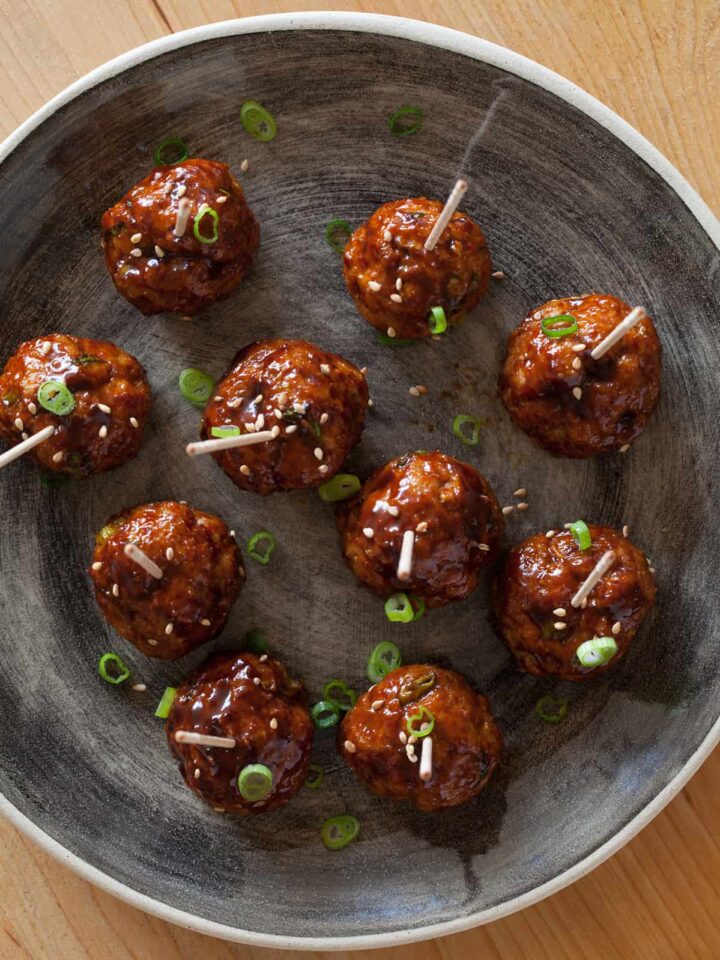 Cocktail meatballs with a Korean chili sauce, topped with green onions.