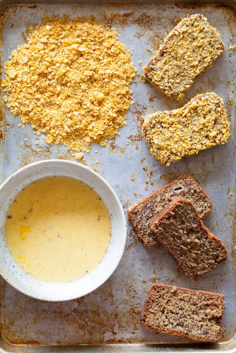 Making Banana Bread French Toast, dredging with crushed corn flakes. A recipe for Banana Bread French Toast coated in corn flakes.