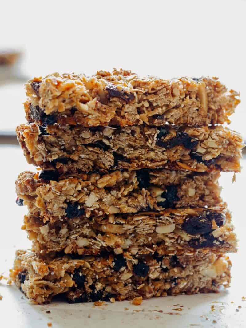 A close up of stacked homemade granola bars with coconut and dried cherries and blueberries.