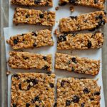 A tray of homemade granola bars with coconut and dried cherries and blueberries.