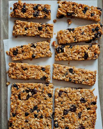 A tray of homemade granola bars with coconut and dried cherries and blueberries.