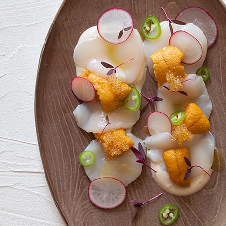 Scallop and uni crudo on a platter. 