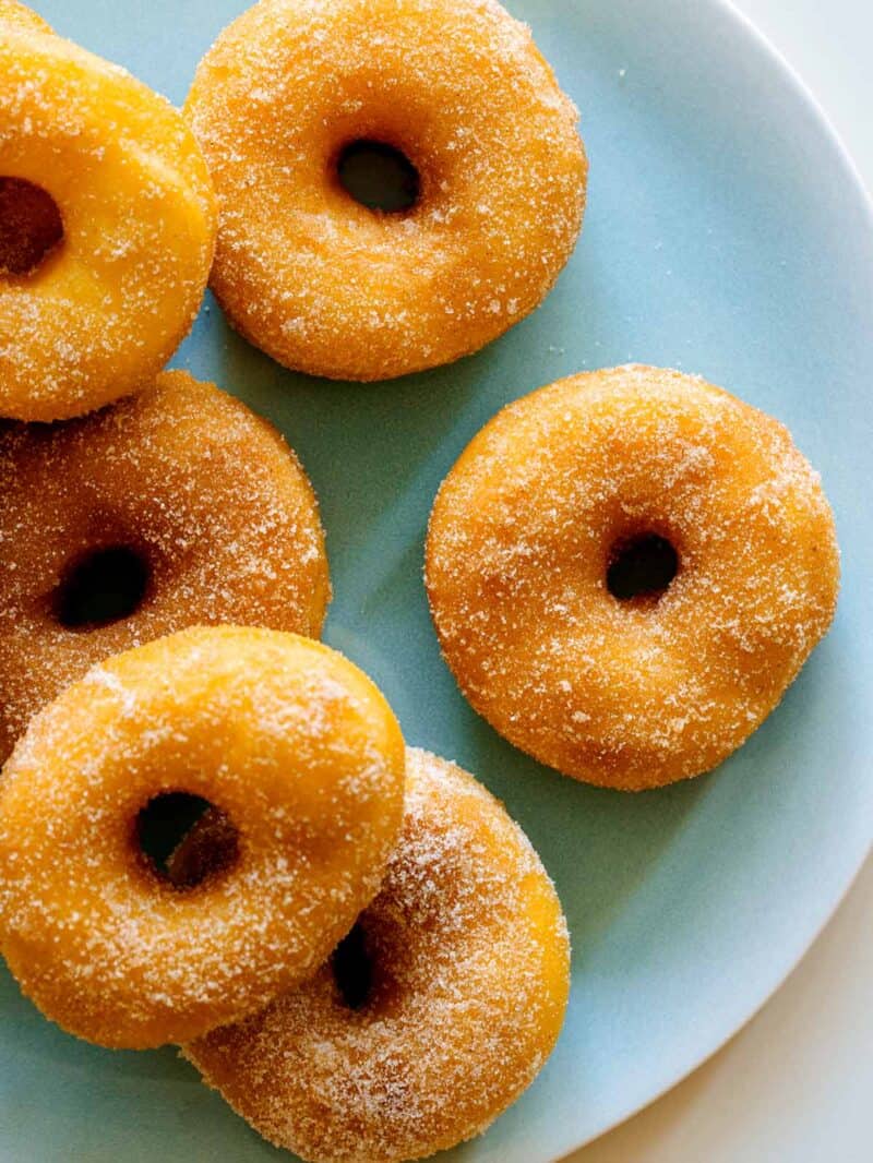 A close up of sweet potato spudnuts coated with sugar and cinnamon.