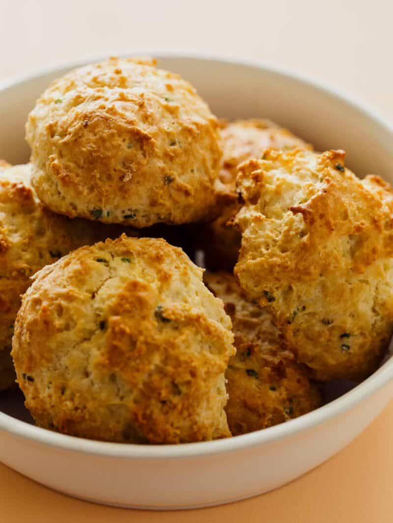Close up of a bowl of sour cream and chive drop biscuits.