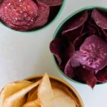 A close up of bowls of different types of root chips.