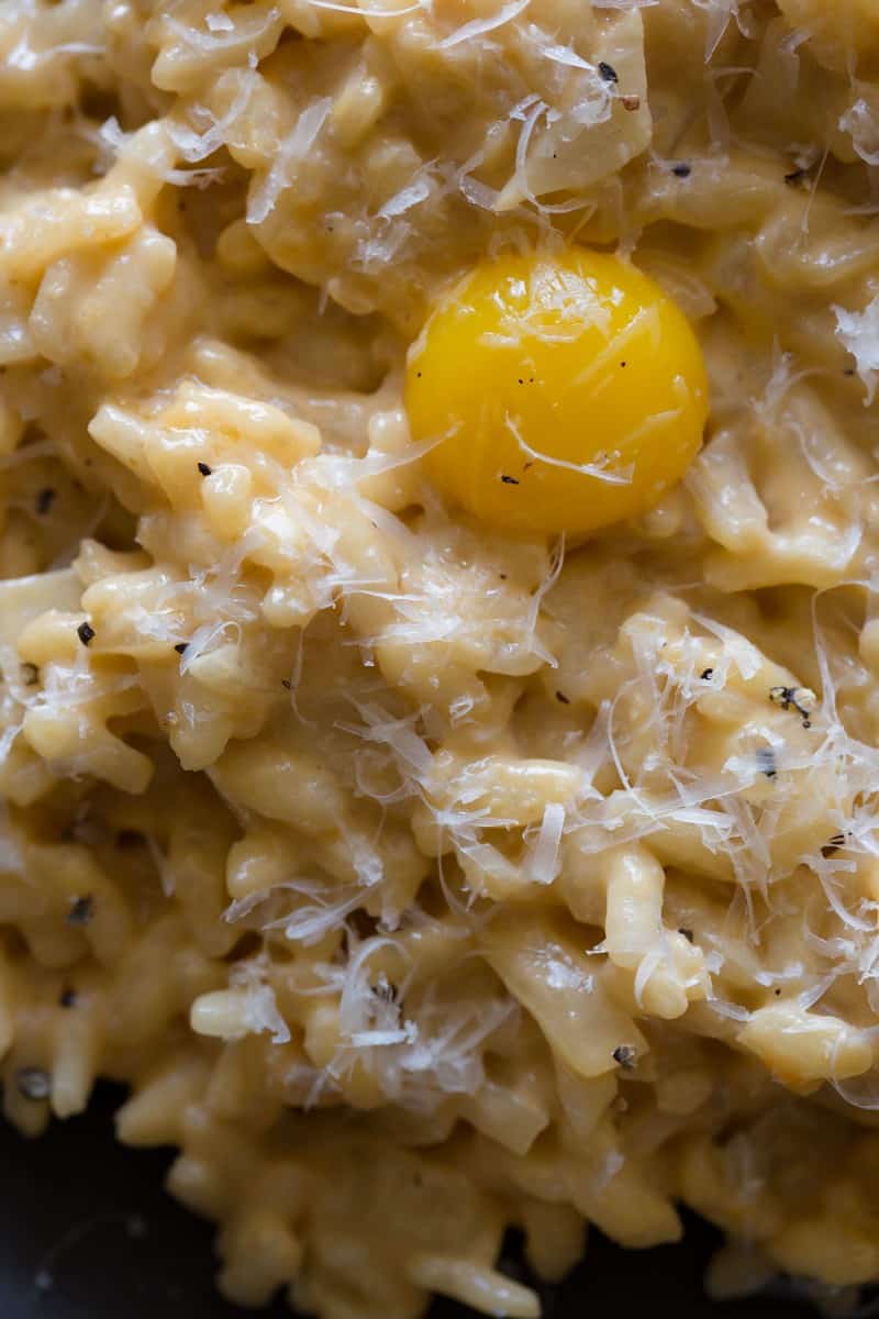 Uni Risotto topped with black pepper, a quail egg yolk, and fresh Pecorino.