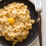 A recipe for an Uni Risotto topped with a quail egg yolk.
