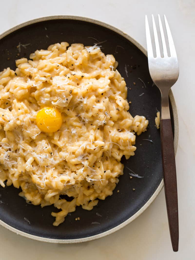 A recipe for an Uni Risotto topped with a quail egg yolk.