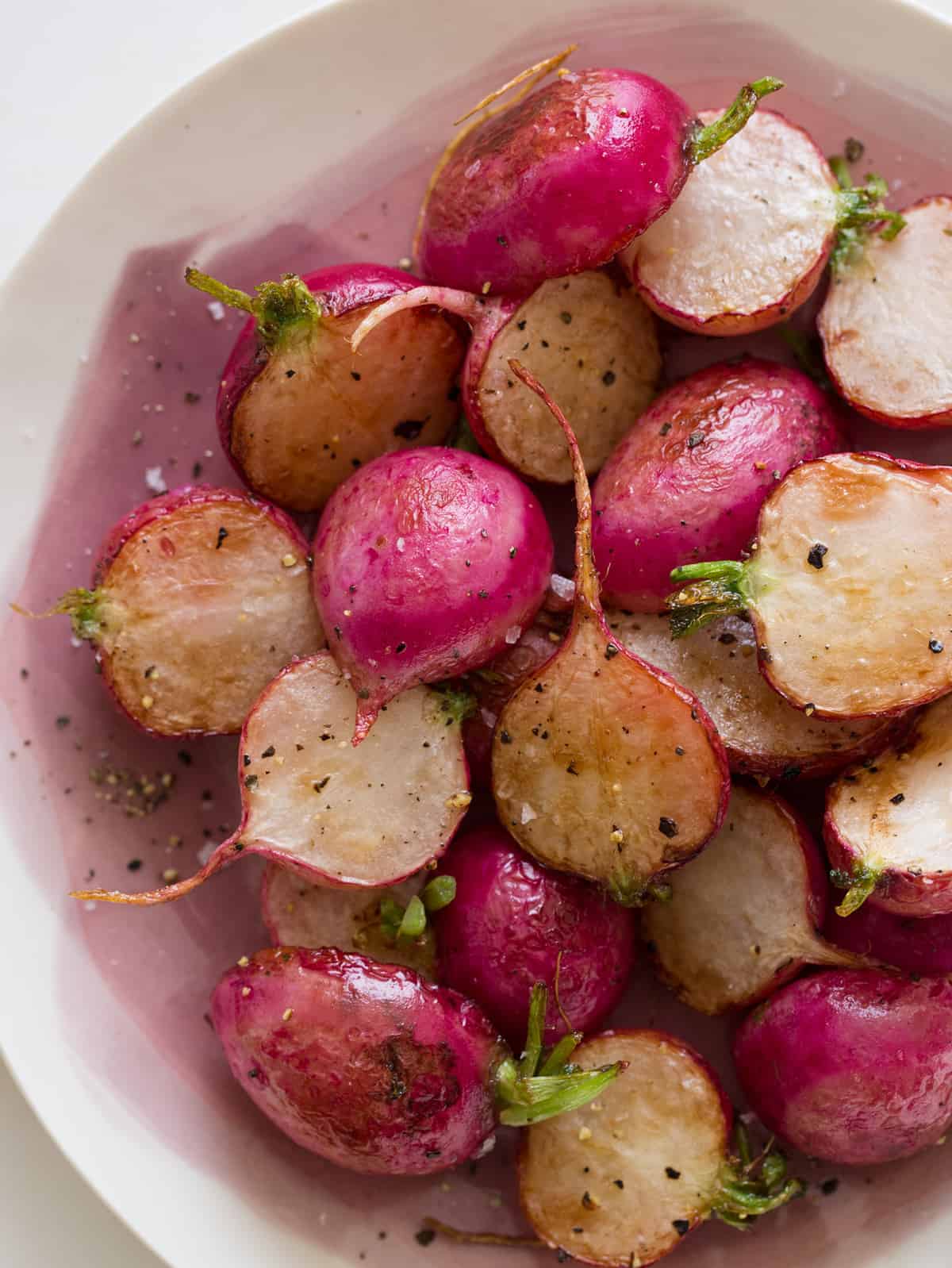 A close up of a bowl of roasted radishes.
