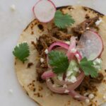 A close up of a cochinita pibil taco.