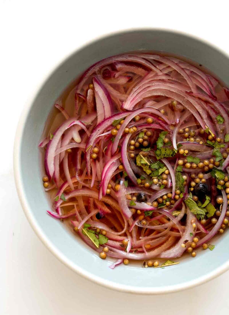 A close up of a bowl of marinading pickled red onions.