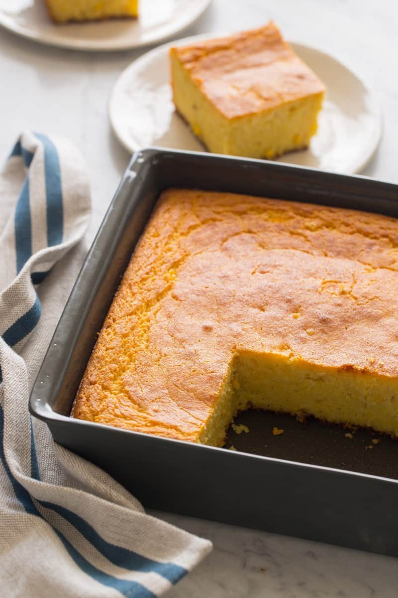 A pan of buttermilk cornbread with pieces cut out and plated.