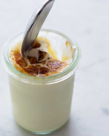 Creme Brulee frozen custard with a cracked topping and spoon in it.