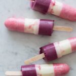 A close up of real fruit bomb pops on a marble surface.