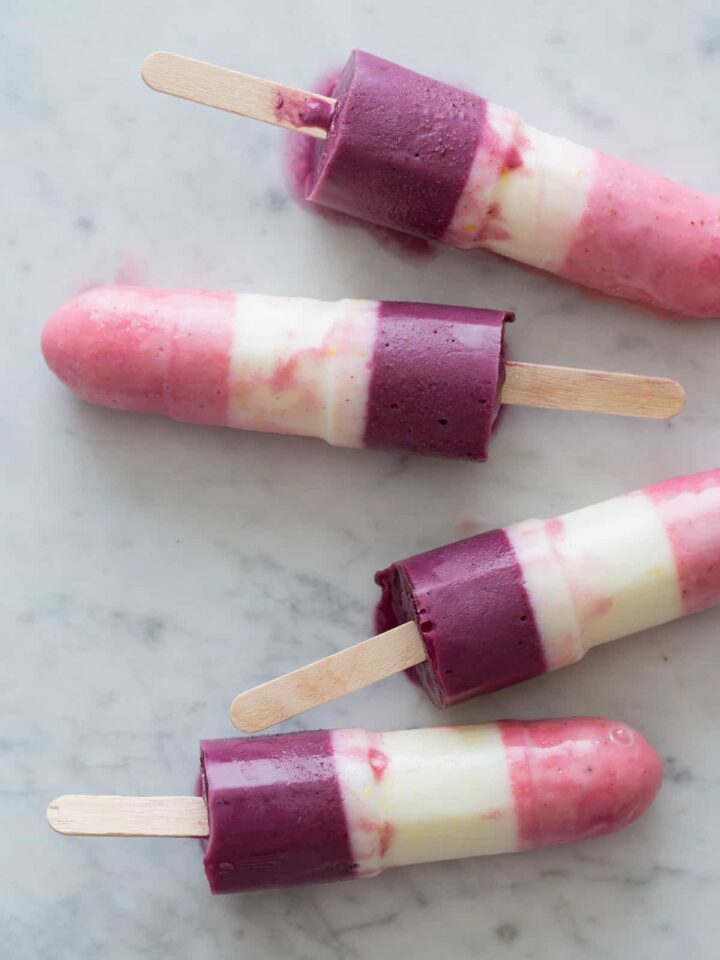 A close up of real fruit bomb pops on a marble surface.