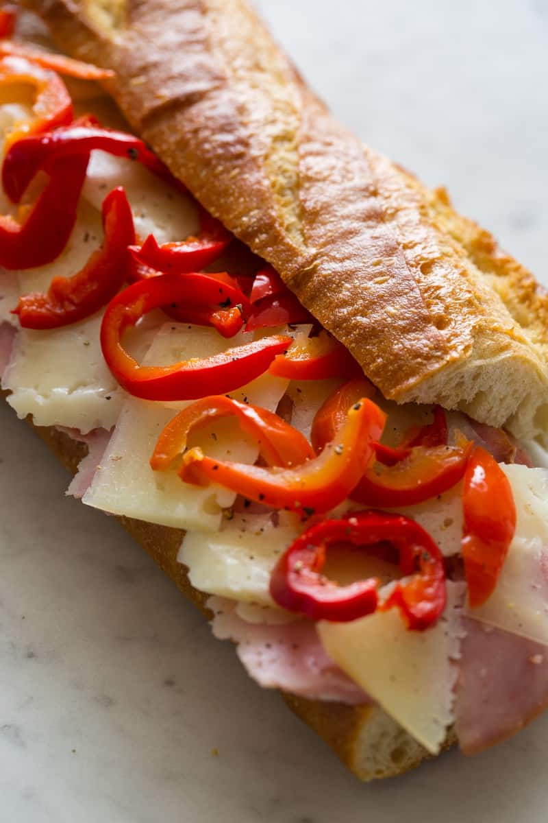 A close up of a whole, slightly open to expose the ingredients bocadillo.