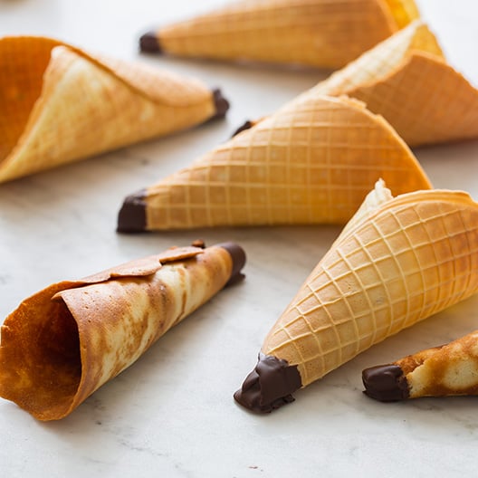 A close up of homemade ice cream cones on a marble countertop.