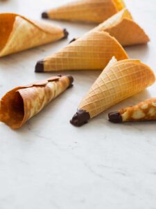 A close up of homemade ice cream cones on a marble countertop.