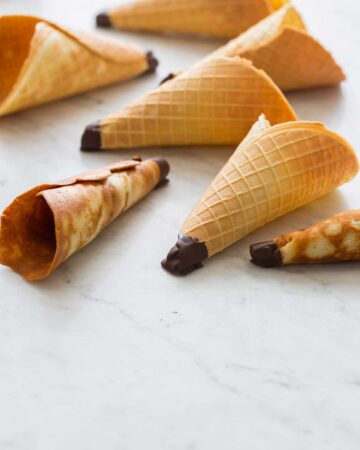 A close up of homemade ice cream cones on a marble countertop.