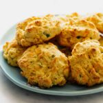 A close up of a plate of cornmeal and jalapeño cheddar biscuits.