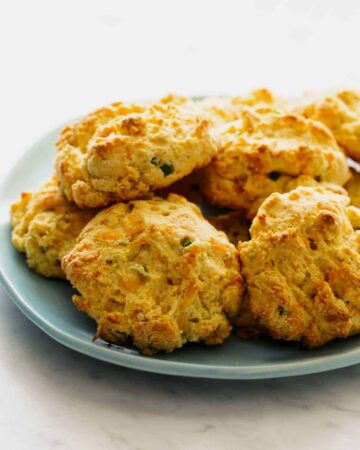 A close up of a plate of cornmeal and jalapeño cheddar biscuits.
