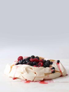A basic pavlova with macerated berries.