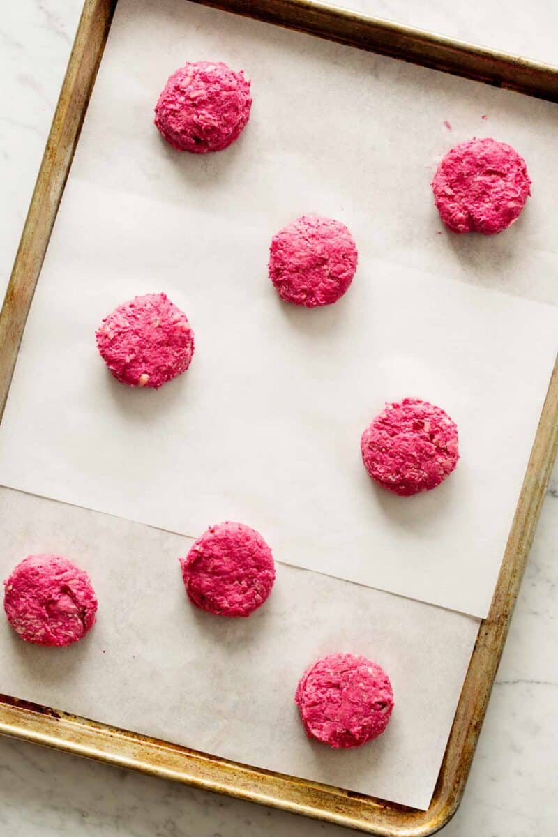 Beet biscuits on a baking sheet ready to be baked. 