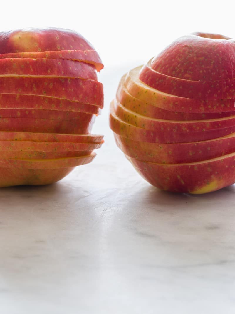 A close up of sliced apples still stacked in their original round shape.