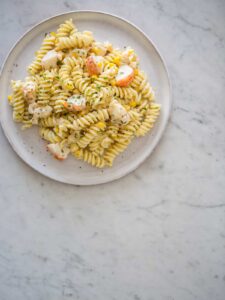 Lobster and corn pasta with white wine and tarragon cream sauce on a plate.