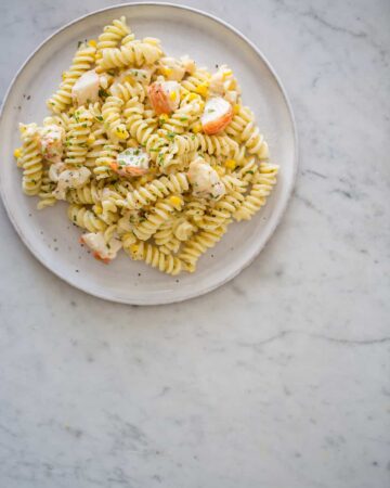 Lobster and corn pasta with white wine and tarragon cream sauce on a plate.