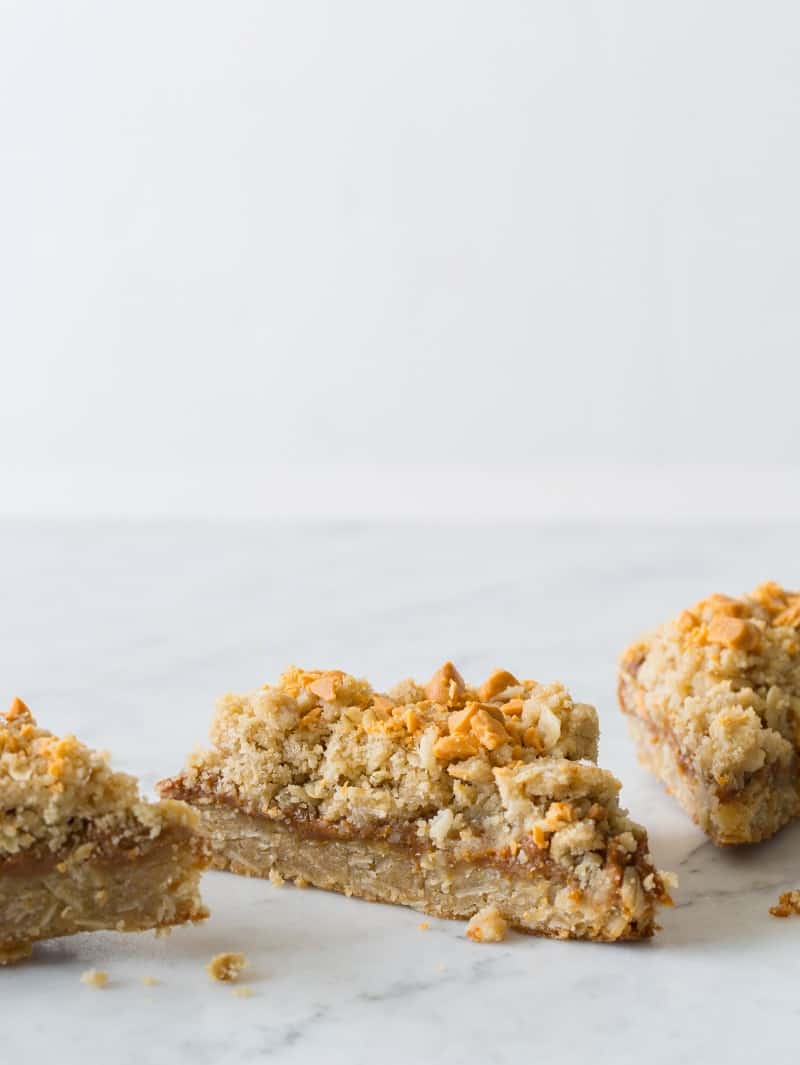 Three pieces of salted dulce de leche bars on a marble counter.