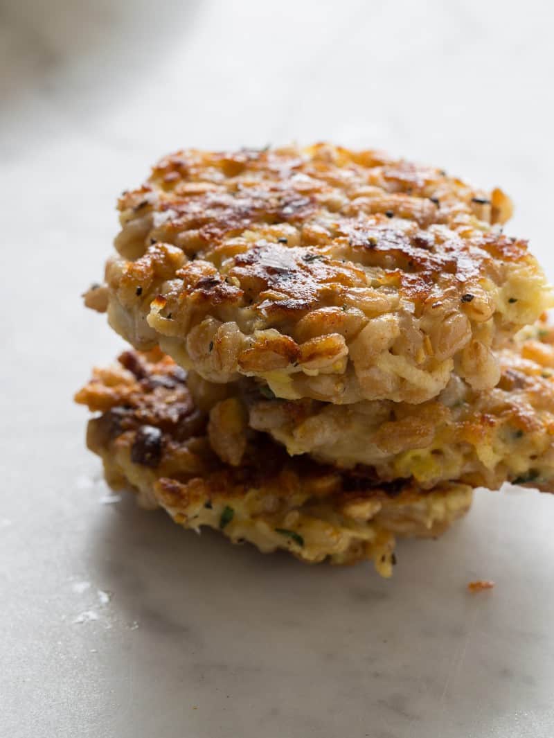 A stack of three apple farro cakes on a kitchen counter.