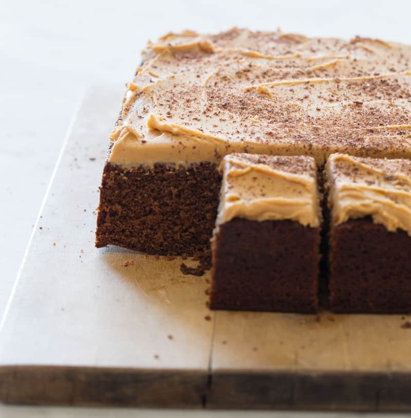 A close up of spicy chocolate stout cake with peanut butter buttercream and a piece removed.