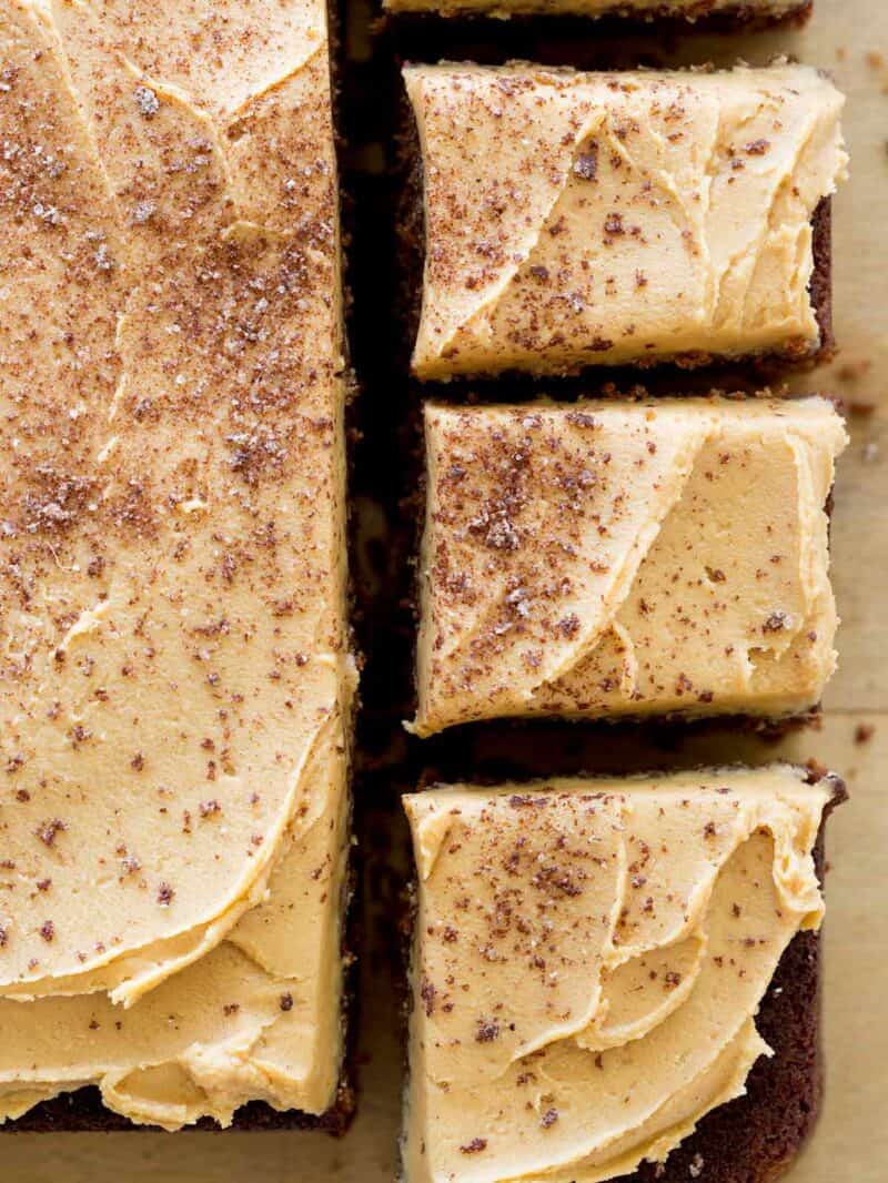 A close up of spicy chocolate stout cake with peanut butter buttercream with square pieces cut.